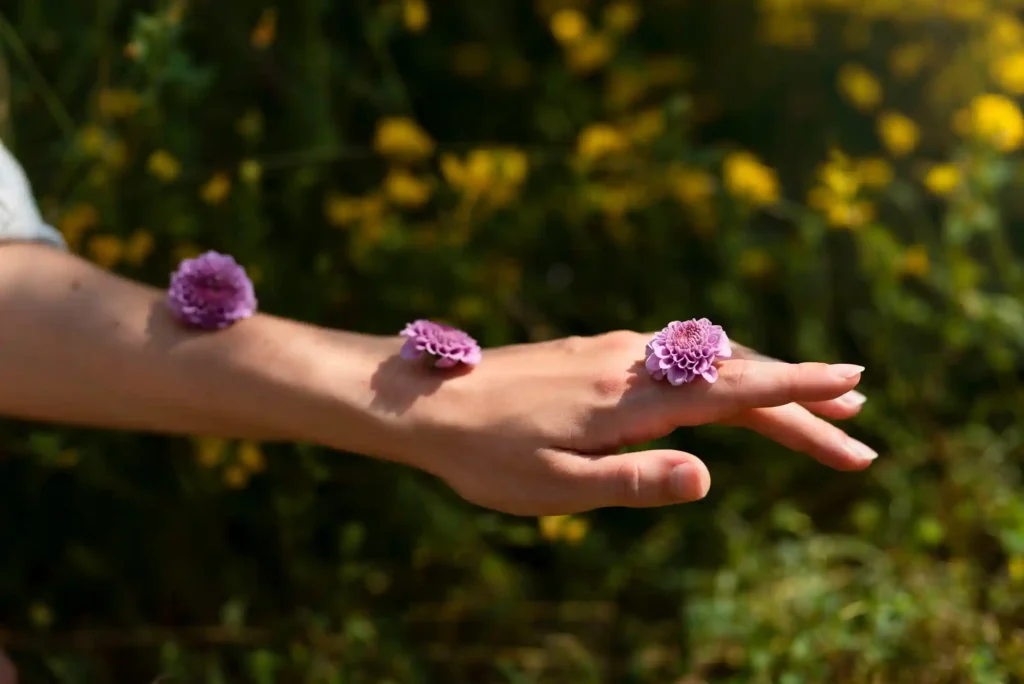 Hand mit kleinen violetten Wildblumen als Symbol für nachhaltigen Lebensstil und bewusste Naturverbundenheit bei oekolifestyle.com